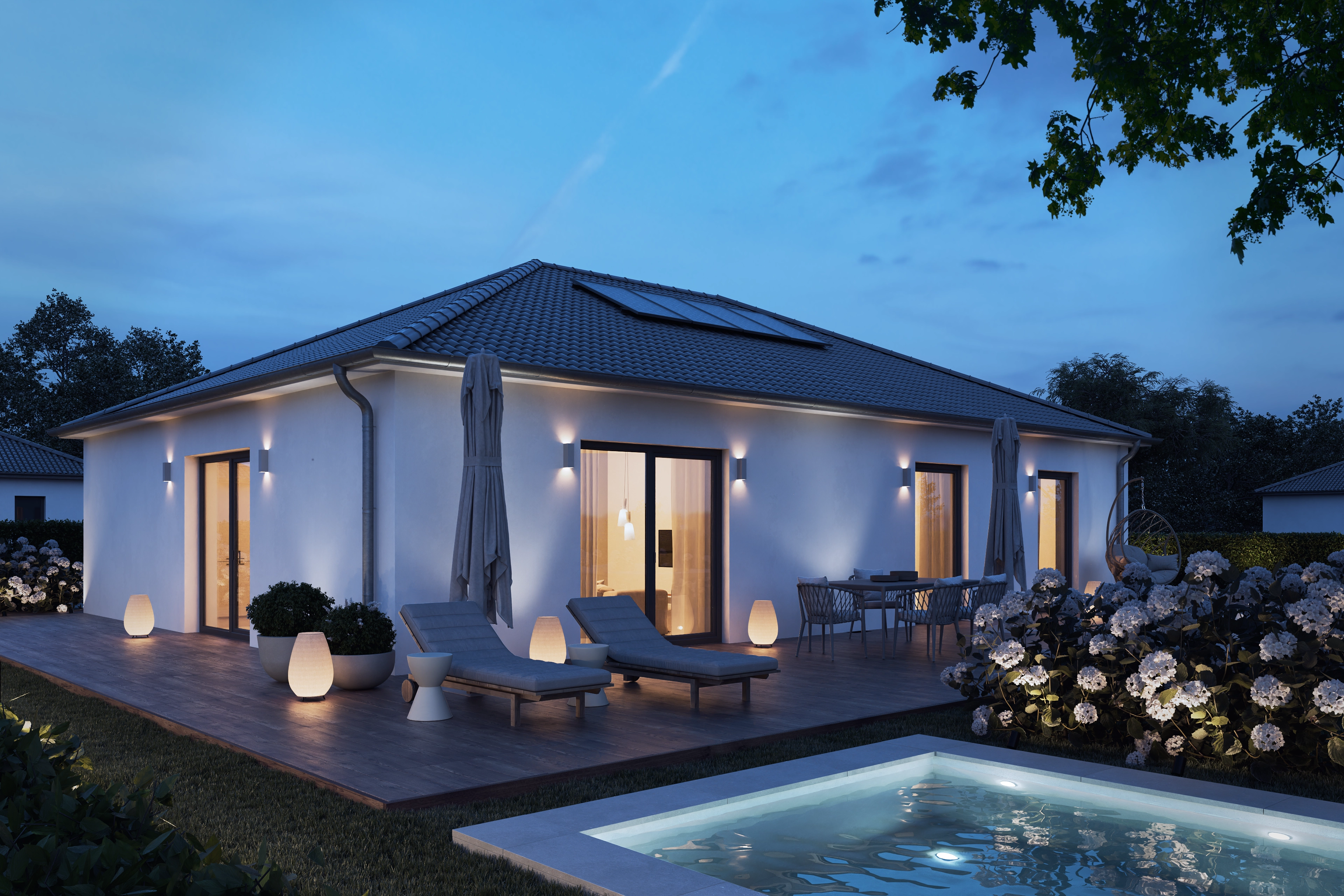 The same single-storey house and pool at dusk with the outdoor lights on