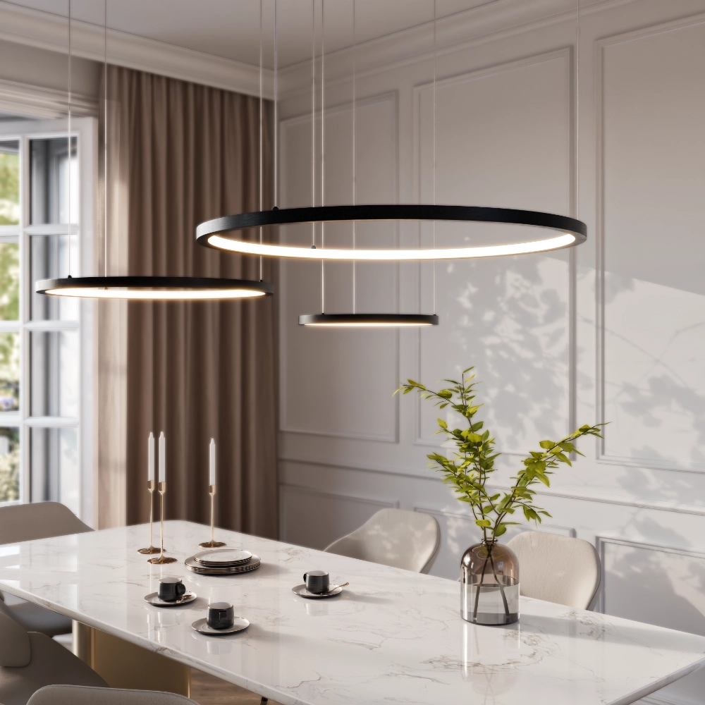 Black ring pendant lights glowing above a marble dining table set for coffee